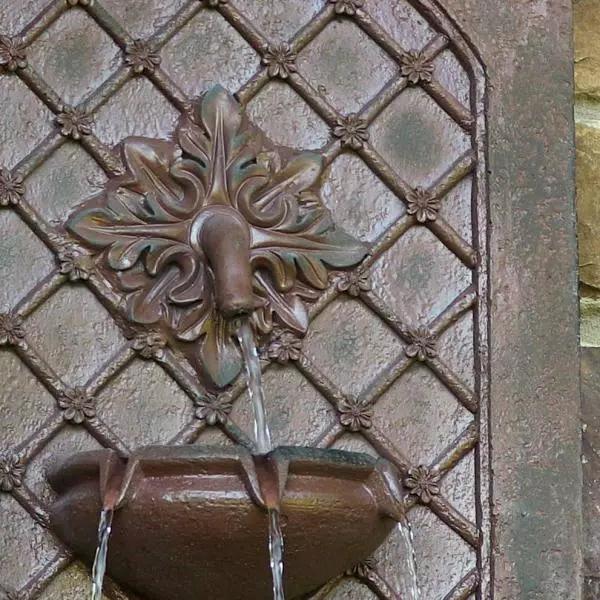 Sunnydaze Decor Rosette Resin Weathered Iron Solar Outdoor Wall Fountain with Battery Backup